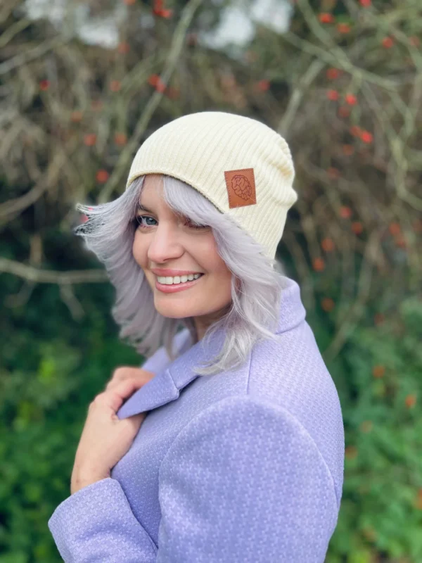 a woman smiling with a ecru hat